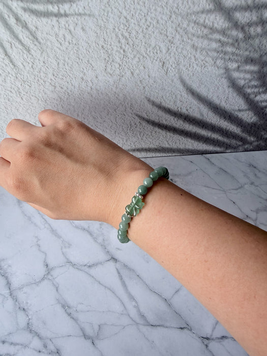 Dreamy Jade bracelet featuring polished green jade beads and a delicate carved jade butterfly charm on a wrist.