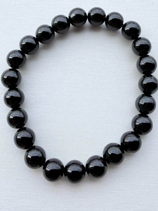 Dreamy Jade polished black obsidian round bead elastic bracelet with a minimalist unisex design
