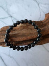 Dreamy Jade black obsidian beaded bracelet with polished round stones on a rustic wooden display