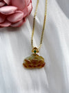 Dreamy Jade carved amber-toned jade pendant necklace with a gold-tone floral setting and green gemstone on a box chain