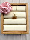 Dreamy Jade necklace with a carved amber-toned jade pendant, gold-tone floral setting, and green gemstone on a chain.