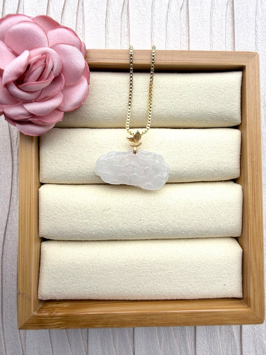 Dreamy Jade elegant white carved jade floral pendant necklace with a gold leaf bail on a gold box chain in a display