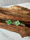 Dreamy Jade clover-inspired rings featuring vibrant green jade stones set in polished silver on a rustic wood background.