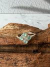 Dreamy Jade clover-inspired ring featuring four mint green jade stones set in polished silver on a rustic wood base.