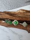 Dreamy Jade clover-inspired rings featuring green jade stones set in polished silver on a rustic wooden display.