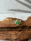 Dreamy Jade clover-inspired ring featuring green jade stones and sparkling accents set in polished silver on wood