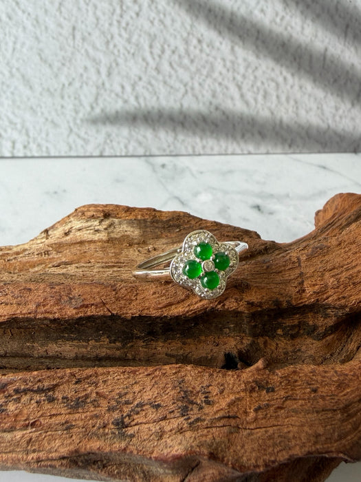 Dreamy Jade clover-inspired ring featuring green jade stones and sparkling accents set in polished silver on wood