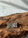 Back view of Dreamy Jade clover stud earrings featuring silver-tone metal posts resting on a textured wooden surface.
