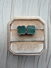 Dreamy Jade clover stud earrings featuring green stone inlay and a beaded metal edge in a velvet jewellery box.