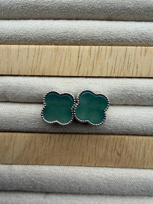 Dreamy Jade clover stud earrings featuring green stone inlay and a delicate beaded metal border on a velvet tray.