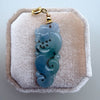 Dreamy Jade mythical dragon pendant carved from translucent blue-green jadeite with a gold-tone clasp on velvet.