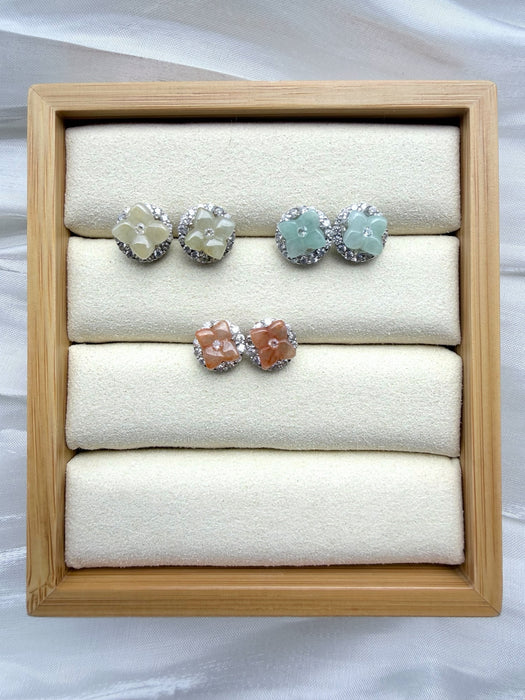 Dreamy Jade floral stud earrings in pastel green, cream, and peach gemstone with crystal halos in a wooden display tray