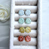 Dreamy Jade floral stud earrings in white, mint green, yellow, and red jade set in a velvet jewellery display case.