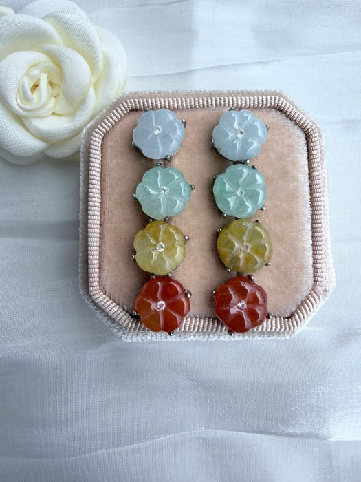 Dreamy Jade floral stud earrings in icy white, mint green, golden yellow, and sunset red on a velvet display box.