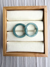 Dreamy Jade pair of polished natural green jadeite bangles displayed in a wooden jewellery box