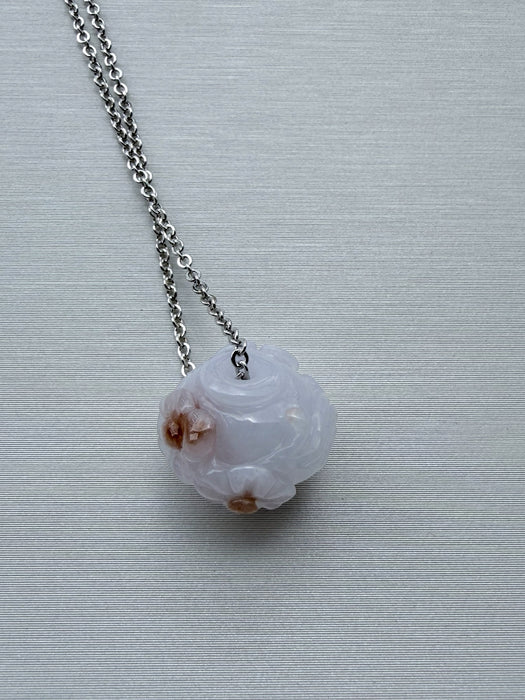 Dreamy Jade lavender jade pendant necklace with hand-carved floral motif and silver-tone chain on a grey background
