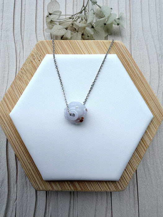 Dreamy Jade lavender jade pendant necklace with hand-carved floral motif on a minimalist silver-tone chain.