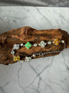 Dreamy Jade multi-coloured jade clover bracelet in 925 sterling silver resting on a piece of natural wood