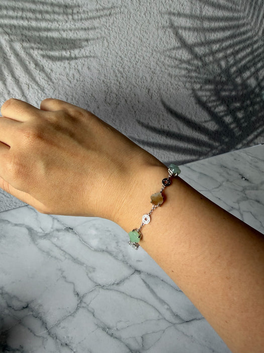 Dreamy Jade multi-coloured clover bracelet in 925 sterling silver worn on a wrist against a marble background.