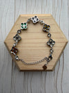Dreamy Jade sterling silver bracelet featuring multi-coloured jade four-leaf clover motifs on a wooden display base.