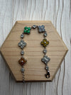 Dreamy Jade multi-coloured clover bracelet with polished jade stones set in 925 sterling silver on a wooden display.