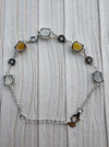 Dreamy Jade multi-coloured jade and 925 sterling silver link bracelet with coin-inspired charms on a textured surface