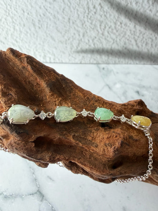 Dreamy Jade multi-coloured jade and sterling silver link bracelet with cubic zirconia accents on a wooden display