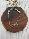 Dreamy Jade multi-coloured jade and sterling silver link bracelet with cubic zirconia accents on a wooden display.