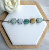 Dreamy Jade multi-coloured floral link bracelet featuring carved jade beads in silver-tone settings on a display stand.