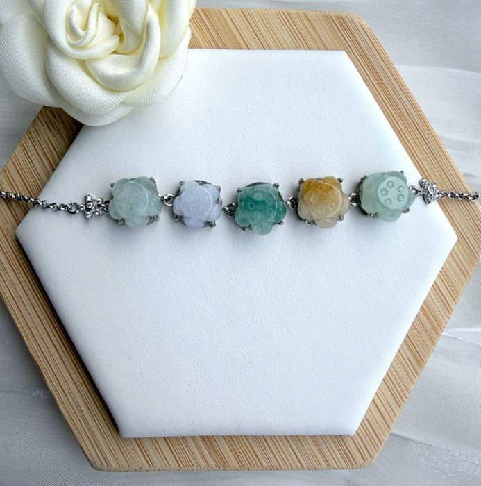 Dreamy Jade multi-coloured floral link bracelet featuring carved jade beads in silver-tone settings on a display stand.