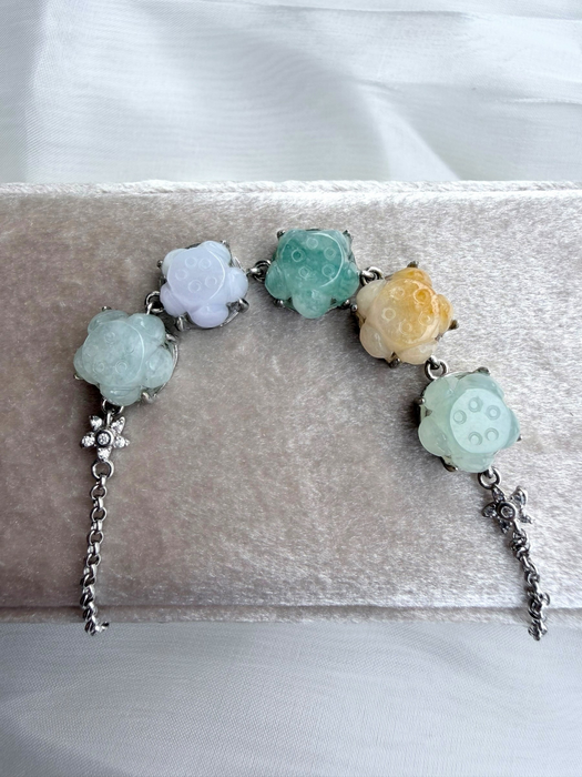 Dreamy Jade multi-coloured floral carved jade gemstone link bracelet with silver-tone chain on a velvet display
