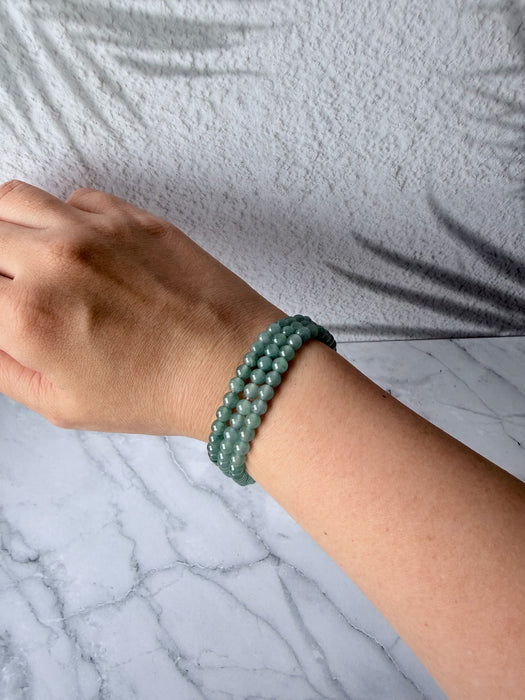 Dreamy Jade multi-layer bracelet featuring smooth, translucent sea-green jade beads on a woman's wrist.