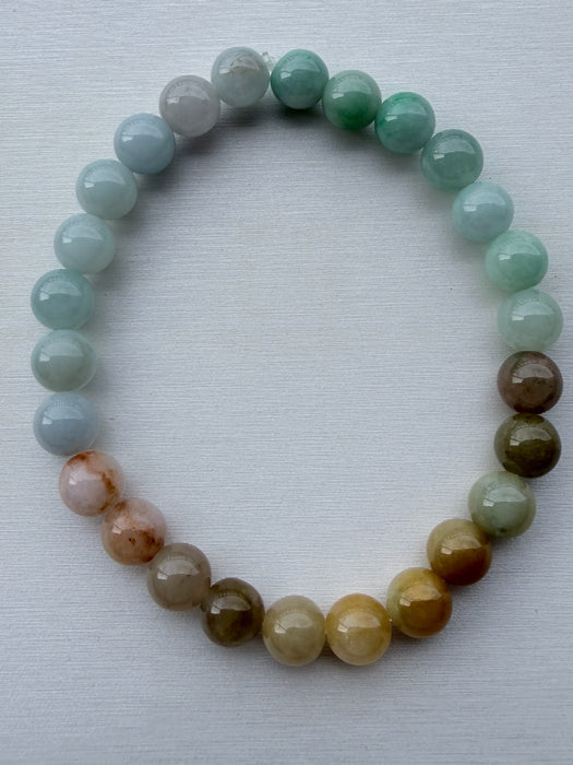 Dreamy Jade multi-colour round bead bracelet featuring a gradient of polished green, white, and amber jade stones.