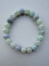 Dreamy Jade bracelet featuring polished natural jadeite beads in soft mint green and lavender hues on a light surface.