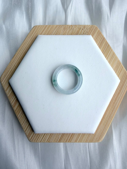 Dreamy Jade elegant natural jadeite ring band with translucent icy base and vibrant green splashes on a white display