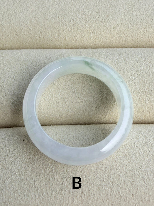 Dreamy Jade natural jadeite ring band with a smooth polished finish and subtle green inclusions on a beige display