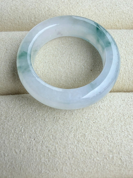 Dreamy Jade elegant natural jadeite ring band with translucent icy base and vibrant green splashes on a velvet tray.