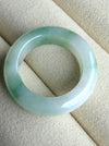 Dreamy Jade natural jadeite ring featuring a polished translucent white band with vibrant emerald green accents.