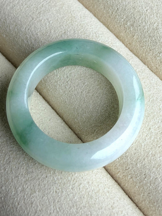 Dreamy Jade natural jadeite ring featuring a polished translucent white band with vibrant emerald green accents.