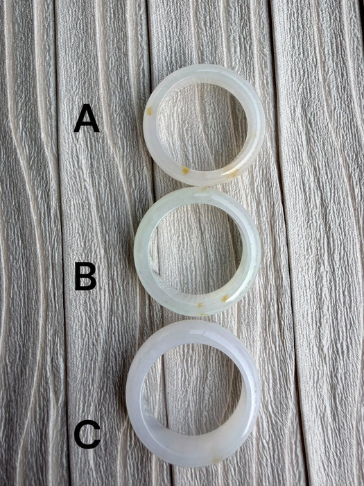Dreamy Jade natural stone band rings in white and pale green, featuring smooth polished finishes and unique textures.