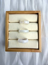 Dreamy Jade natural stone band rings with smooth polished finish displayed in a wooden jewellery tray