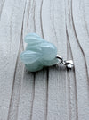 Dreamy Jade elegant pale green carved jade rabbit pendant with a polished silver-tone bail on a textured surface