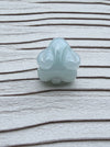 Dreamy Jade pale green carved rabbit pendant with a smooth polished finish on a textured white background