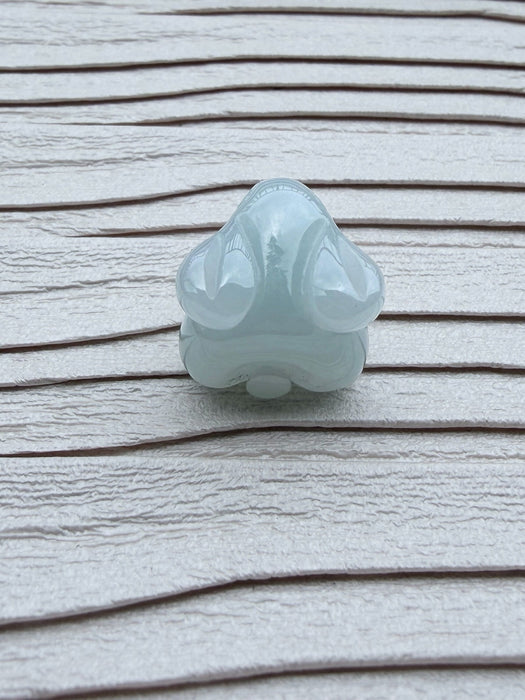 Dreamy Jade pale green carved rabbit pendant with a smooth polished finish on a textured white background