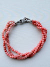 Dreamy Jade triple-strand pink gemstone beaded bracelet with a silver-tone infinity clasp and pavé crystals.