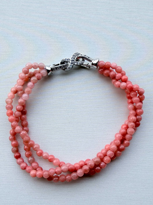 Dreamy Jade triple-strand pink gemstone beaded bracelet with a silver-tone infinity clasp and pavé crystals.