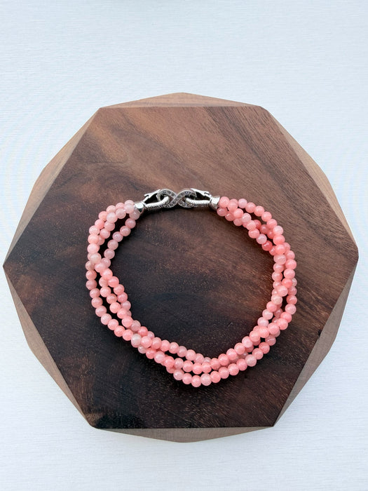 Dreamy Jade triple-strand pink gemstone beaded bracelet with a silver-tone infinity clasp featuring pavé crystals.