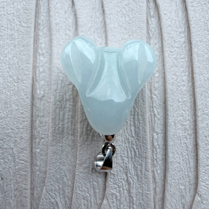 Dreamy Jade rabbit pendant in smooth pale green jade with a polished silver-tone bail on a textured white background.
