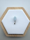 Dreamy Jade light grey translucent jade rabbit pendant with a polished silver-tone bail on a hexagonal display stand.