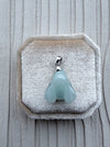 Dreamy Jade pale green carved rabbit pendant with a silver-tone bail resting on a beige velvet jewellery box